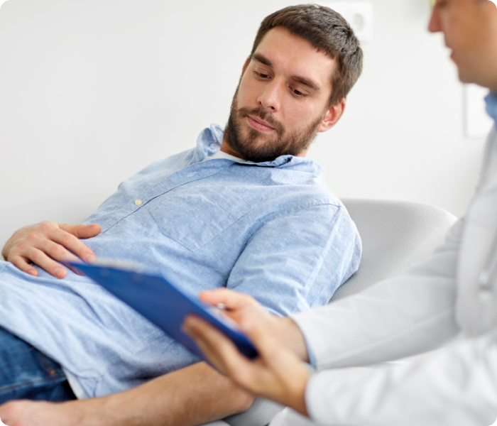 Homem jovem branco em consulta com um médico. Possivelmente, em uma avaliação de fertilidade, buscando um diagnóstico para infertilidade masculina.