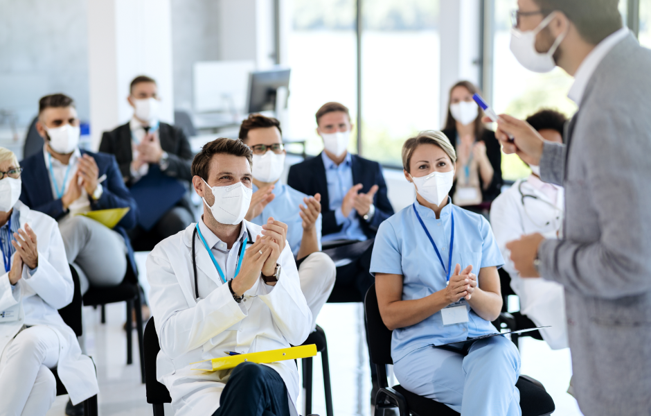 Profissionais da saúde sentados ouvindo um professor, remetendo ao programa PronatusMed da Clínica Pronatus.