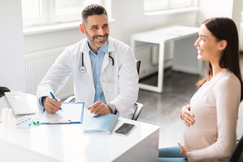 Mulher grávida em consulta com médico obstetra.